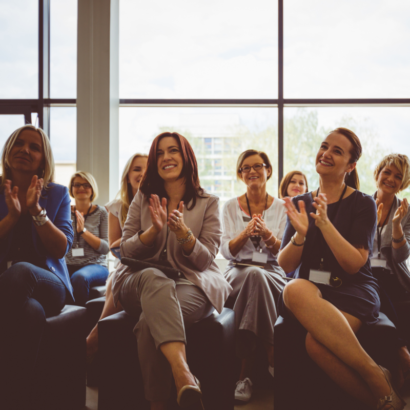 Women in an intimate setting applauding