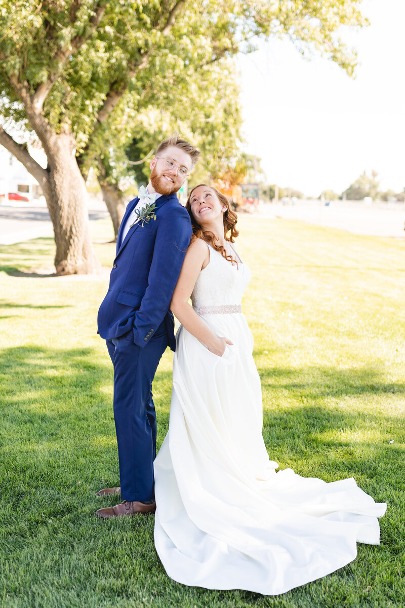 bride in blue elopement dress hugging herself and looking over her shoulder