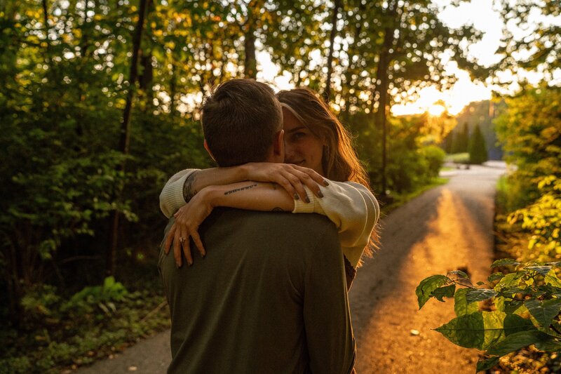 Engaged couple embrace on a golden hour path at Holcomb Gardens, Butler University, Indianapolis