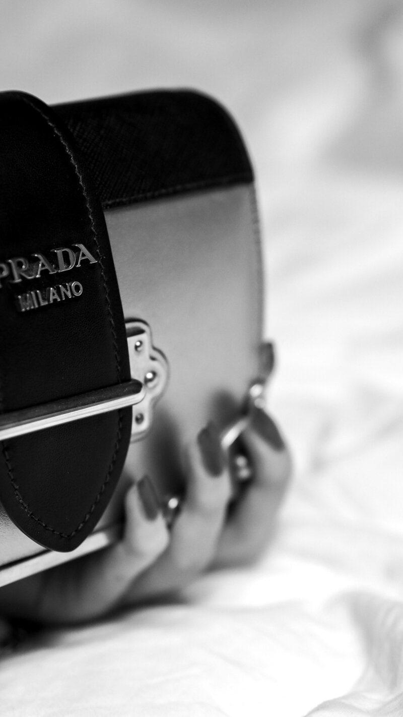 Black and white camera in the hand of a woman with black nails.