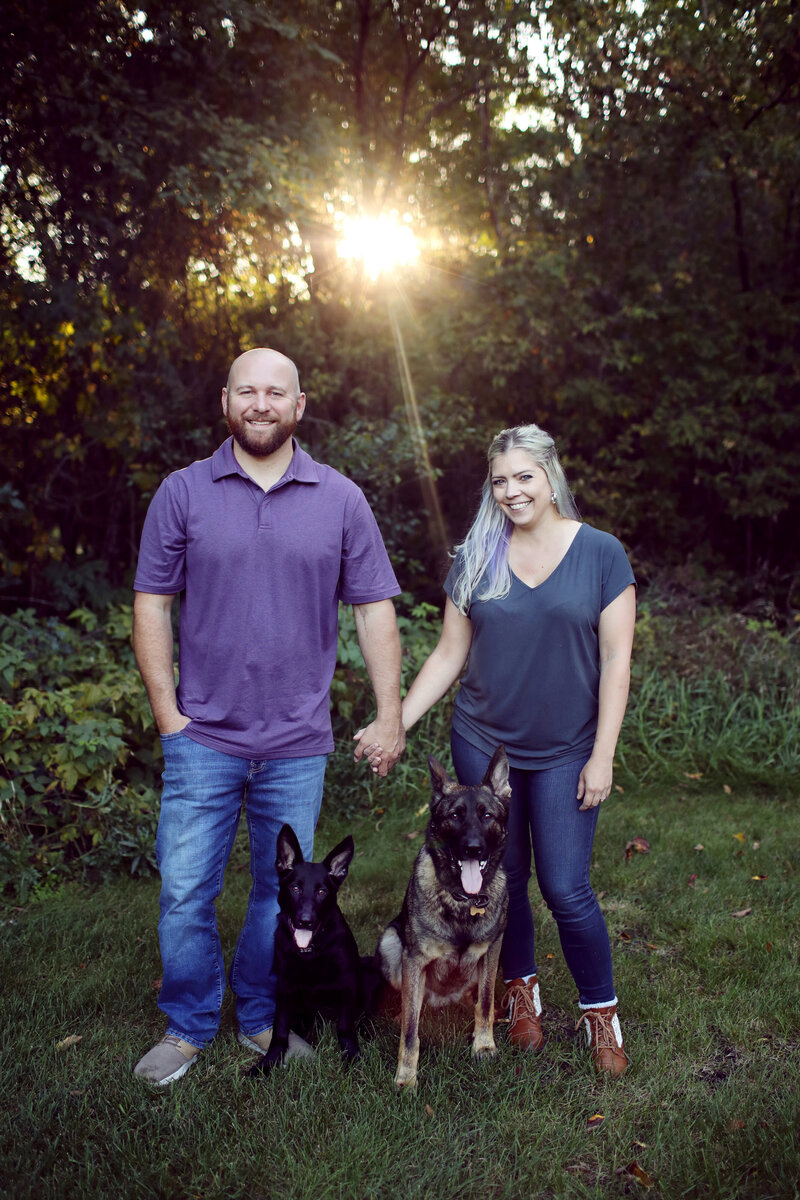 Rachel Parsell and her husband hold hands in nature with their 2 dogs