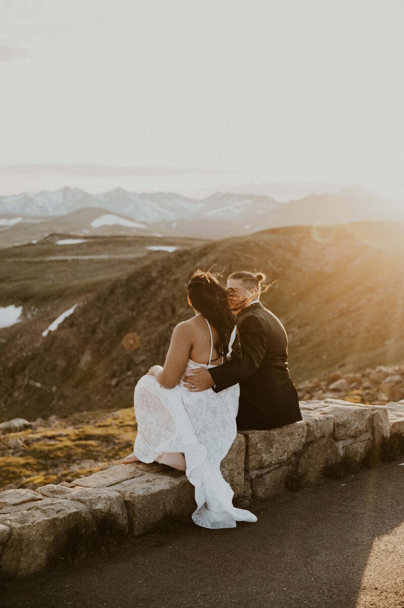 Couple looking out at the mountains duirng sunset on their Rocky Mountain National Park Elopement day, captured by Rocky Mountain National Park Elopement Photographers.
