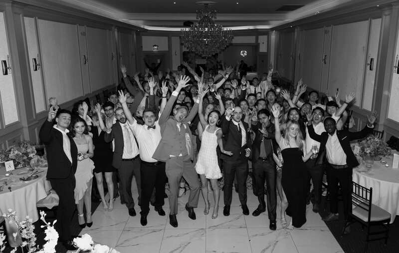 group photo of every guest with bride and groom on the dancefloor during lively reception in New York