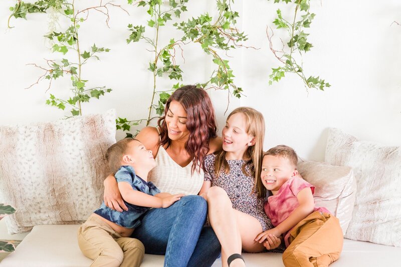 kids looking up at mom on couch laughing. Sugarhill Studio, Longmont, Colorado