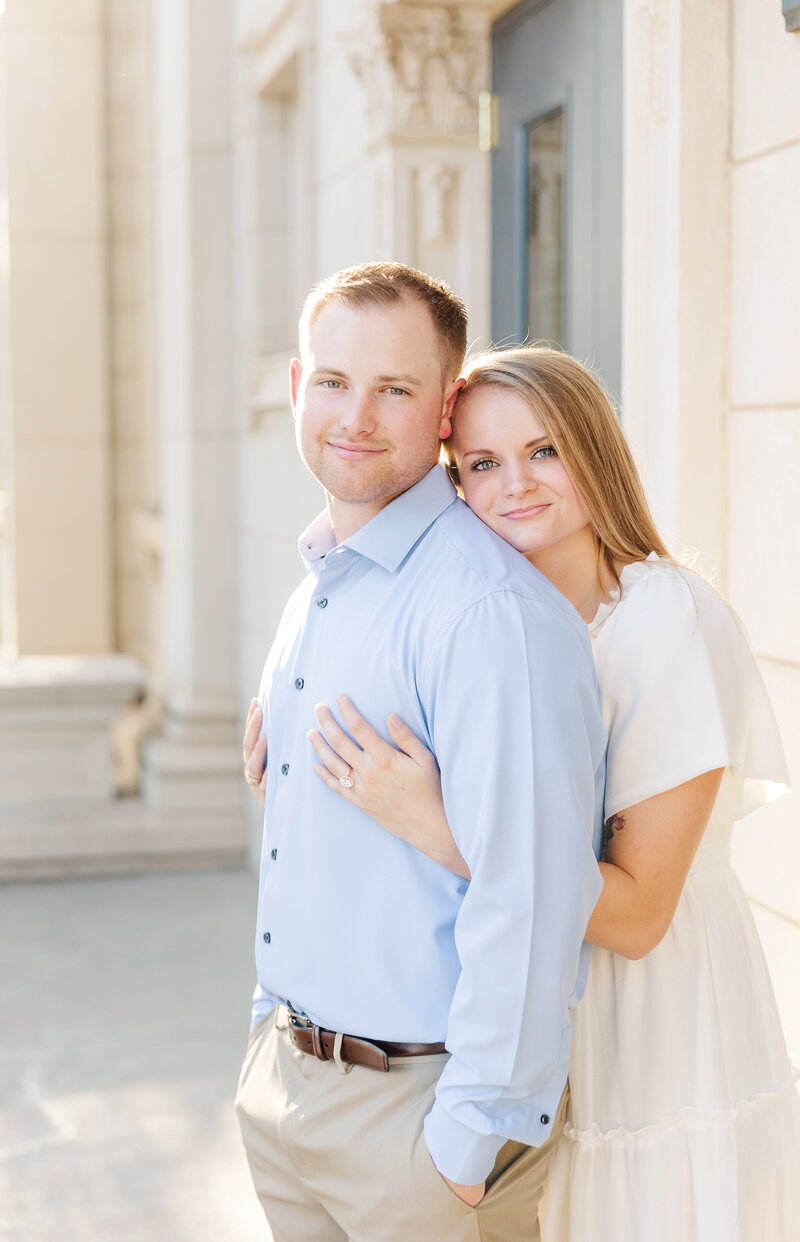 San Antonio wedding photographer captures bride and groom smiling while holding a San Antonio florist's bouquet.