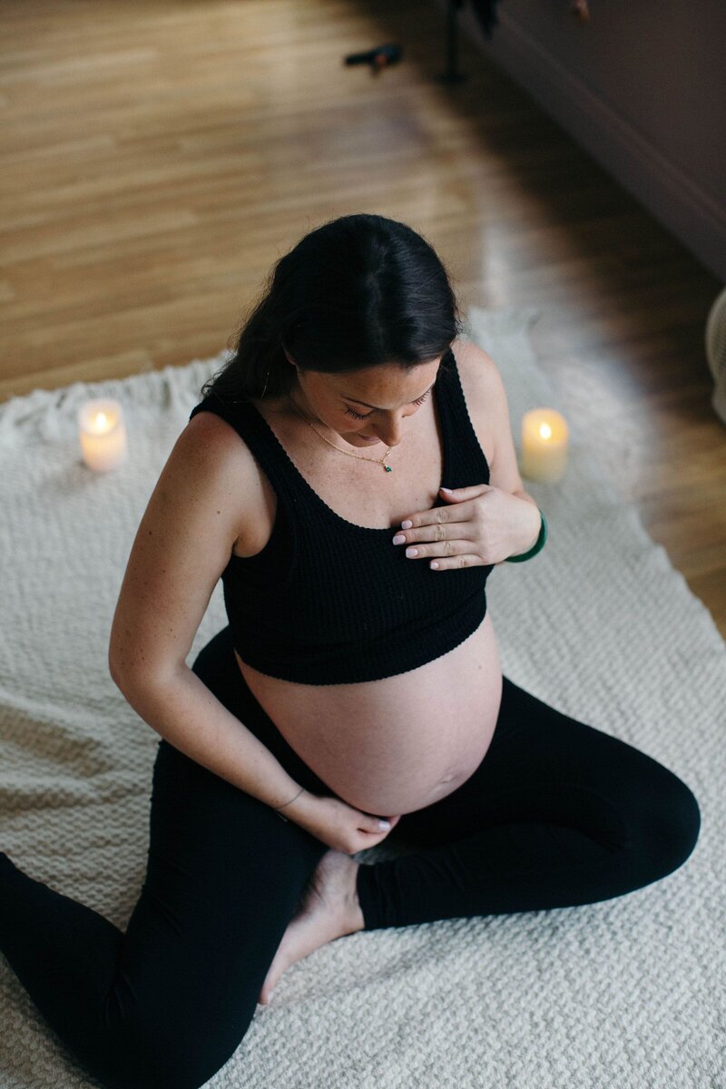 Mariella pregnant on a yoga mat with candles