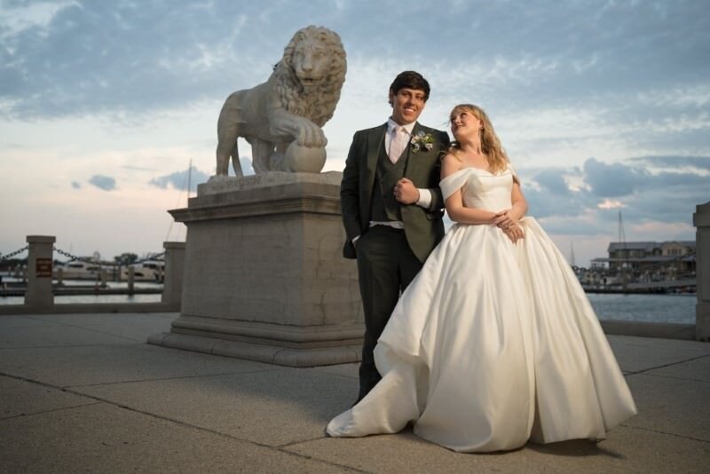 bride and groom pose in front of the lions on the bayfront in st augustine florida
