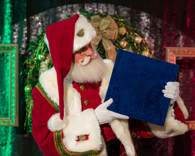 Santa Claus holding a 12x12 wedding album, highlighting its large size and festive charm.