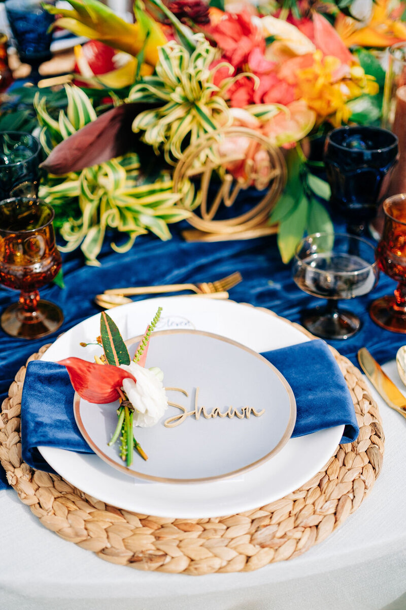 Luxury wedding tablescape blending rich textures, featuring elegant linens, layered charger plates, fine glassware, and lush floral arrangements for a sophisticated destination wedding.