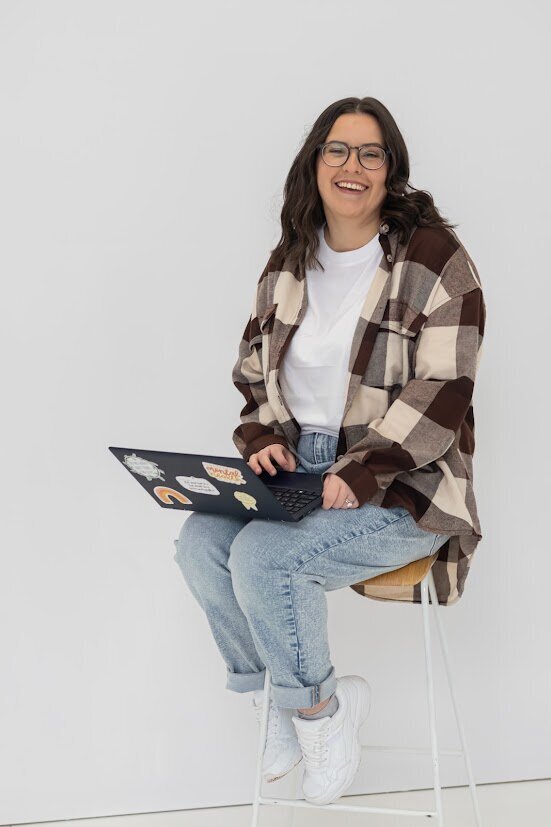 Kirsten from KP Virtual Assistance sitting in a cozy workspace, working on a laptop to set up Studio Ninja systems, reflecting her professional and approachable support for photographers