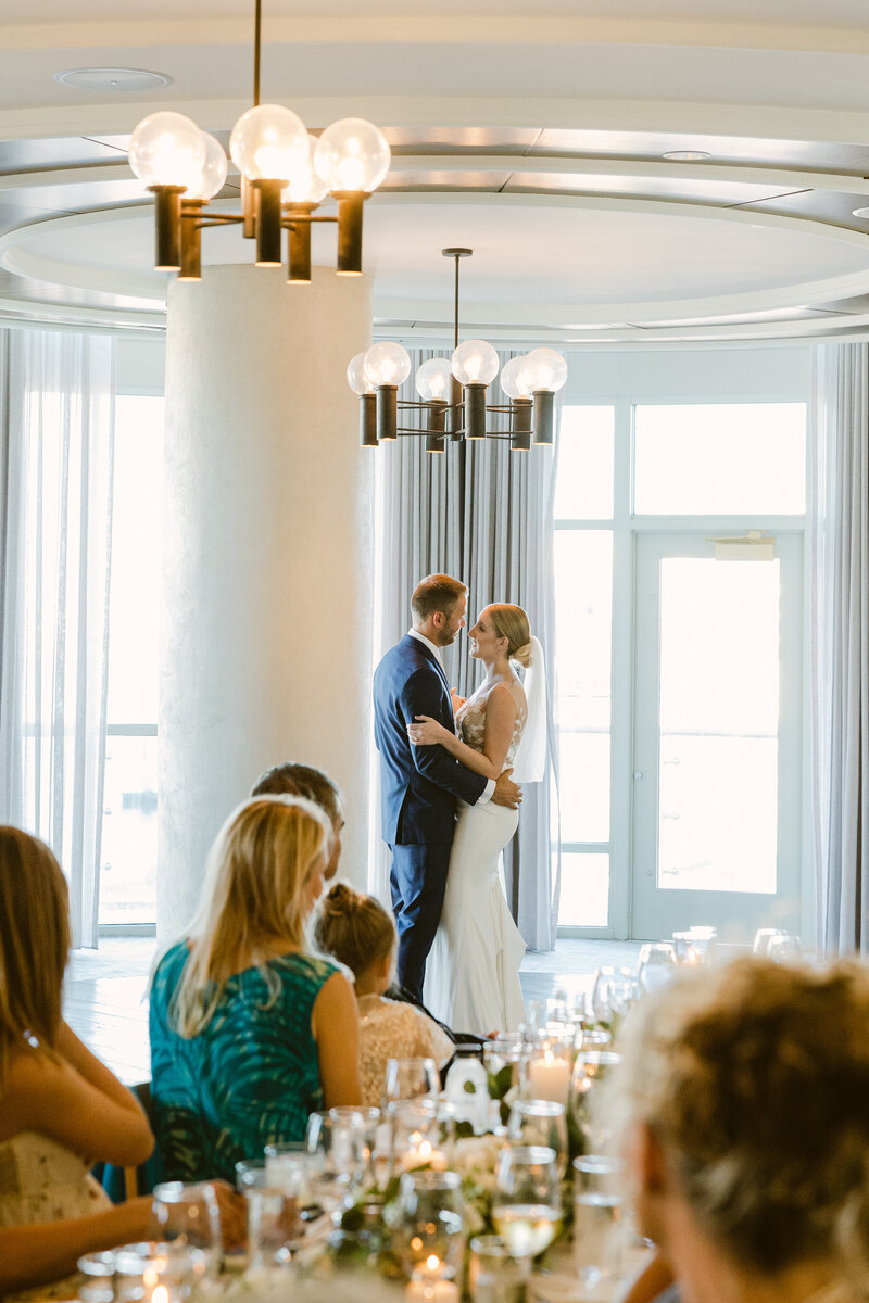 A newlywed couple shares a romantic first dance at The Alida Hotel in Savannah, Georgia. A luxury wedding reception filled with warm candlelight and elegant decor.