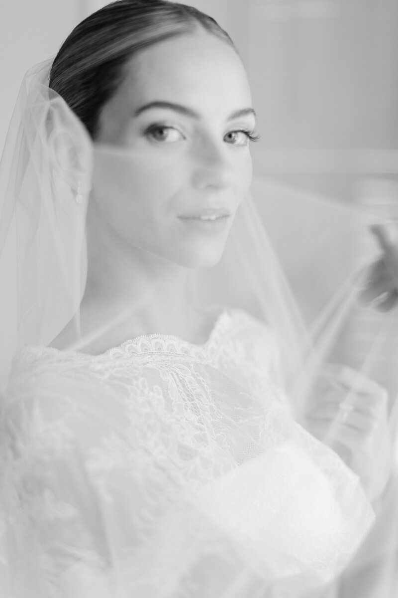 A bride smiling with a veil.