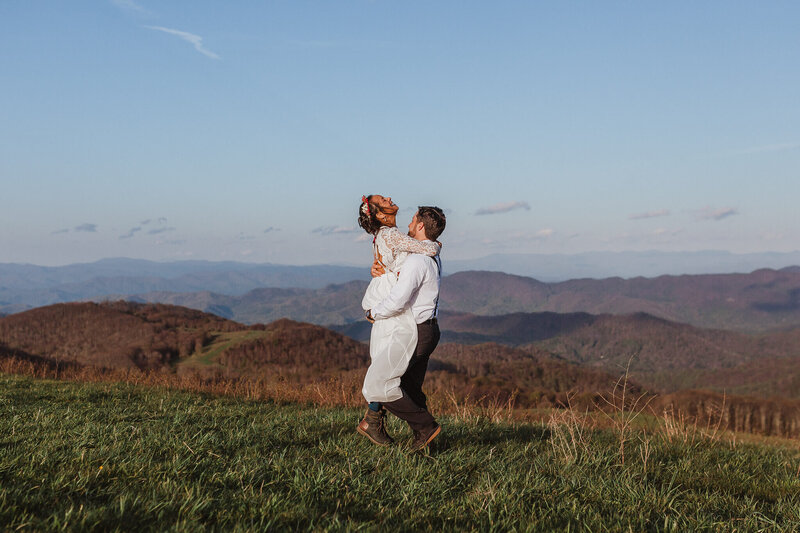 Couple laughing and embracing during their wedding day in Asheville, NC.