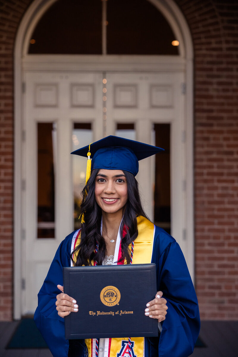 University of Arizona graduate holding her diploma