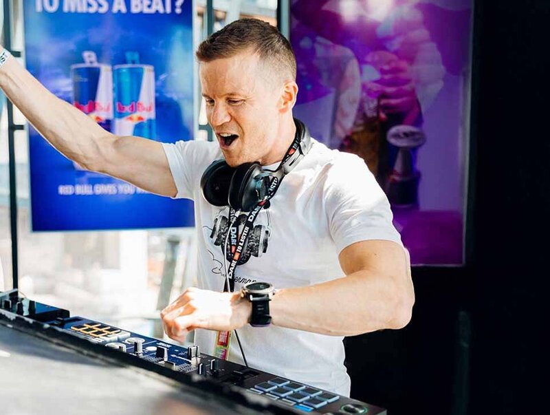Dance floor DJ playing latest beats with hand raised pumping up the crowd