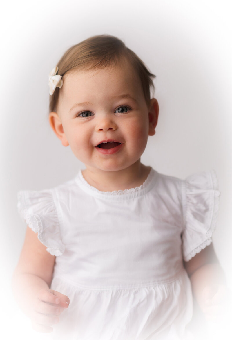 Baby smiles at the camera during Baby Milestone Studio Portrait Session in Charleston, South Carolina. 