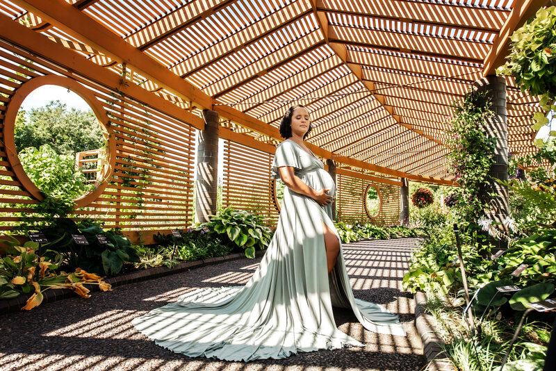 st-louis-maternity-photographer-mom-in-sage-green-gown-under-trellis-with-shadows-at-missouri-botanical-garden-mobot