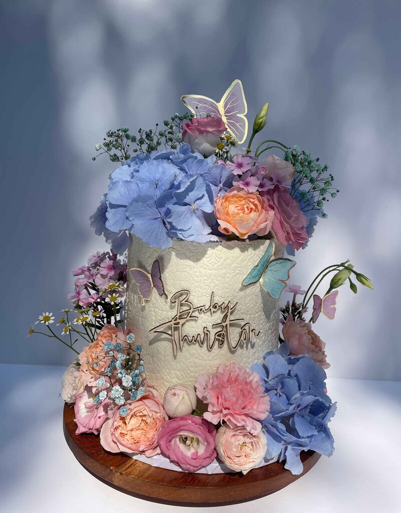 Baby shower cake with soft pastel icing and sugar bow – bespoke design in Cambridgeshire