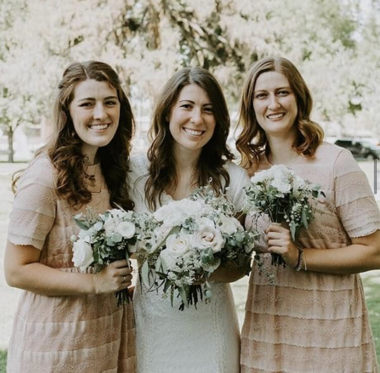 bride with all her bridesmaids holding bright and beautiful bouquets made by Buds Blooms and Blossoms 