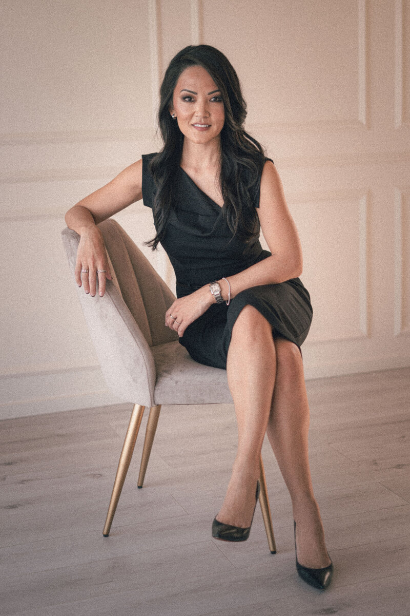 Sandy Chang, brand strategist, seated confidently in black dress, representing elevated personal branding style.