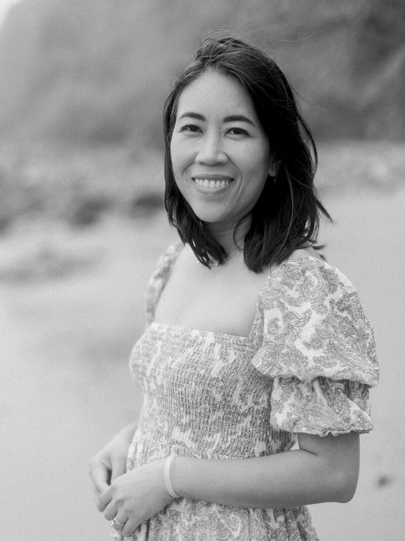 black and white photo of cassy velazquez wearing a dress at the beach