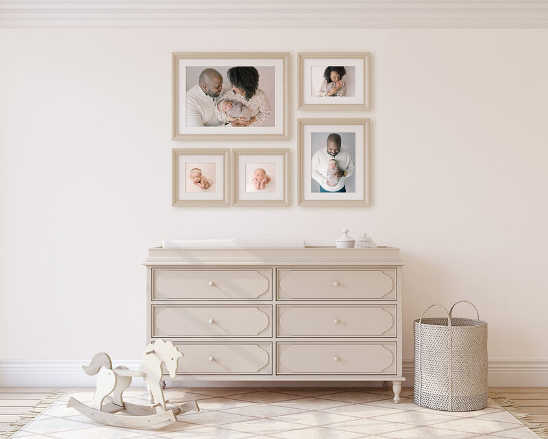 A gallery wall of framed newborn portraits.