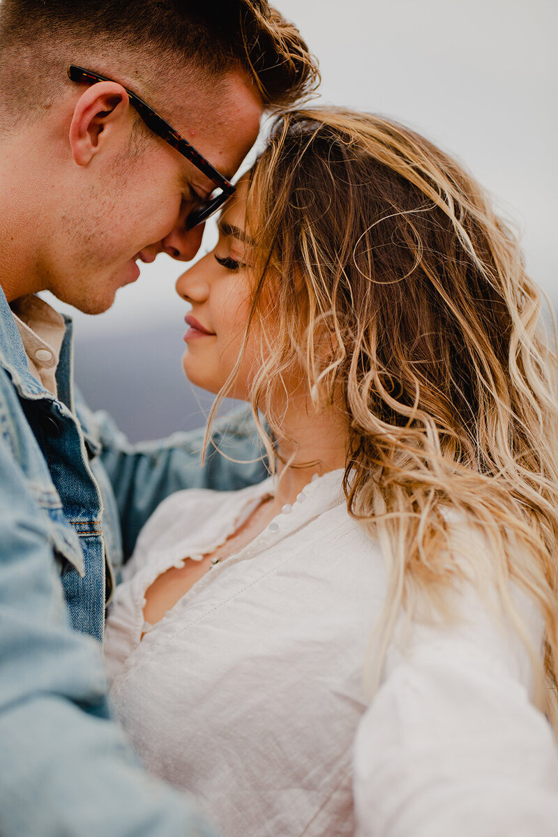 A blonde girl poses quietly with her head on her boyfriend