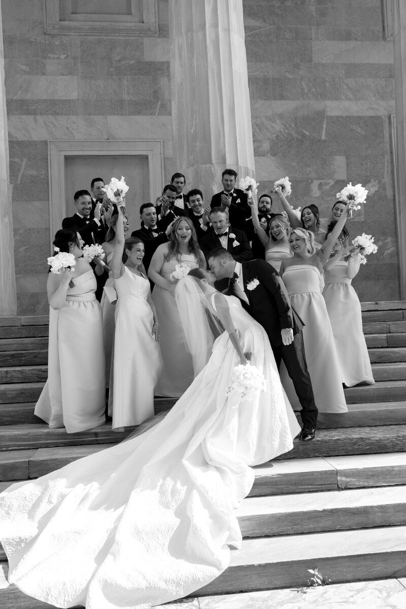 Close up of a bride with a low cowl back dress holding a dried bouquet with dainty tattoos on her arms