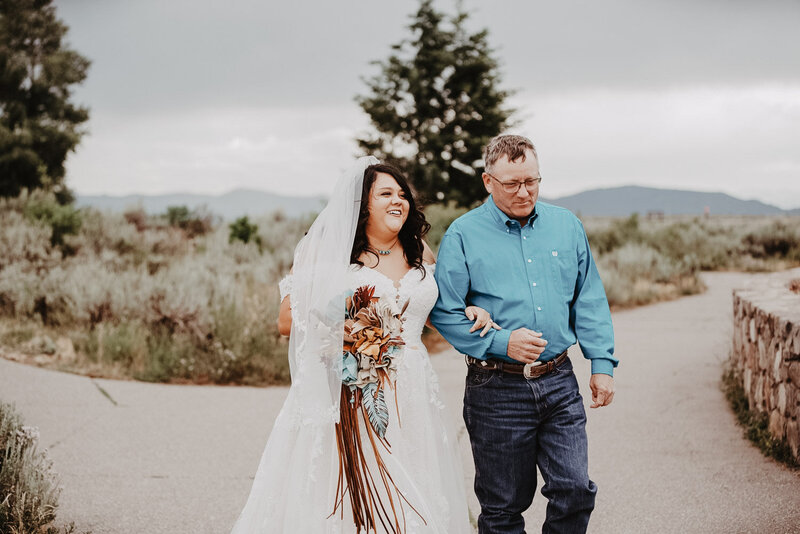 grand teton wedding with bride and her father walking together into her outdoor wedding ceremony captured by best jackson hole wedding photographer