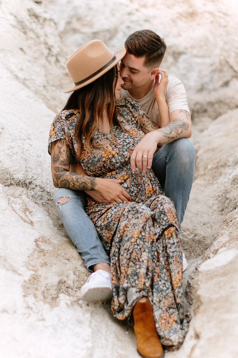 A glowing expectant mother poses gracefully in a serene desert landscape during her maternity photo session.