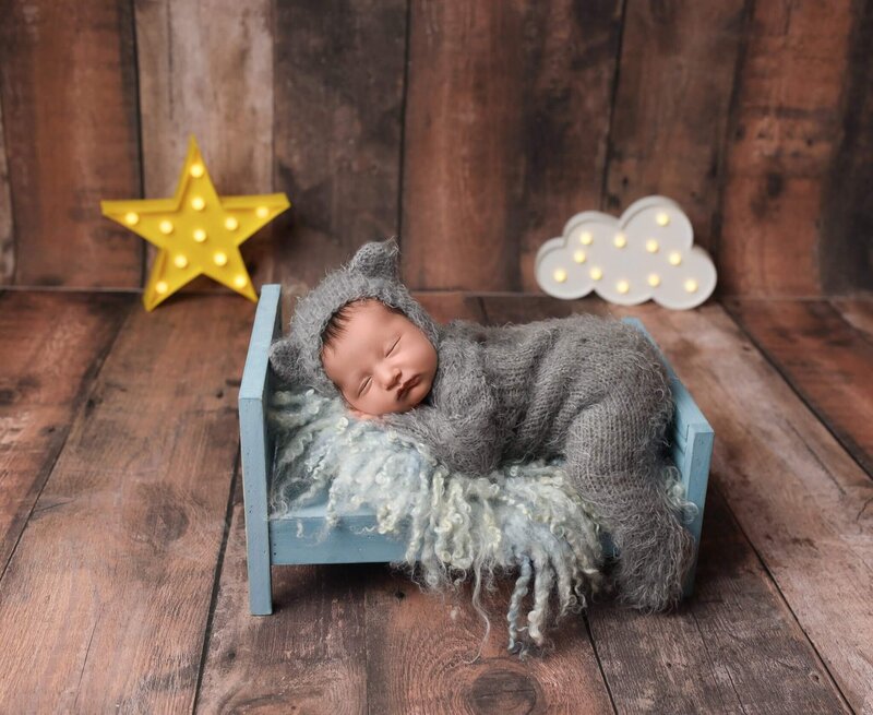 sleeping newborn wearing fuzzy warm bear outfit