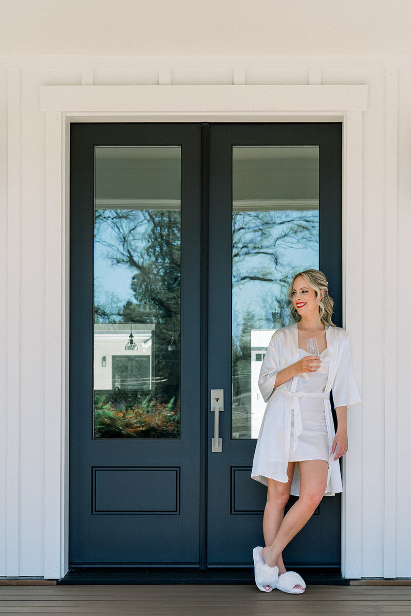 Tiffany Longeway Photography captures an elegant and relaxed moment of bridal preparation at Carneros Resort and Spa in Napa Valley. The bride, dressed in a stylish robe, enjoys a quiet moment with a glass of champagne against the backdrop of this luxurious venue. Ideal for couples seeking a sophisticated and serene setting for their wedding day.