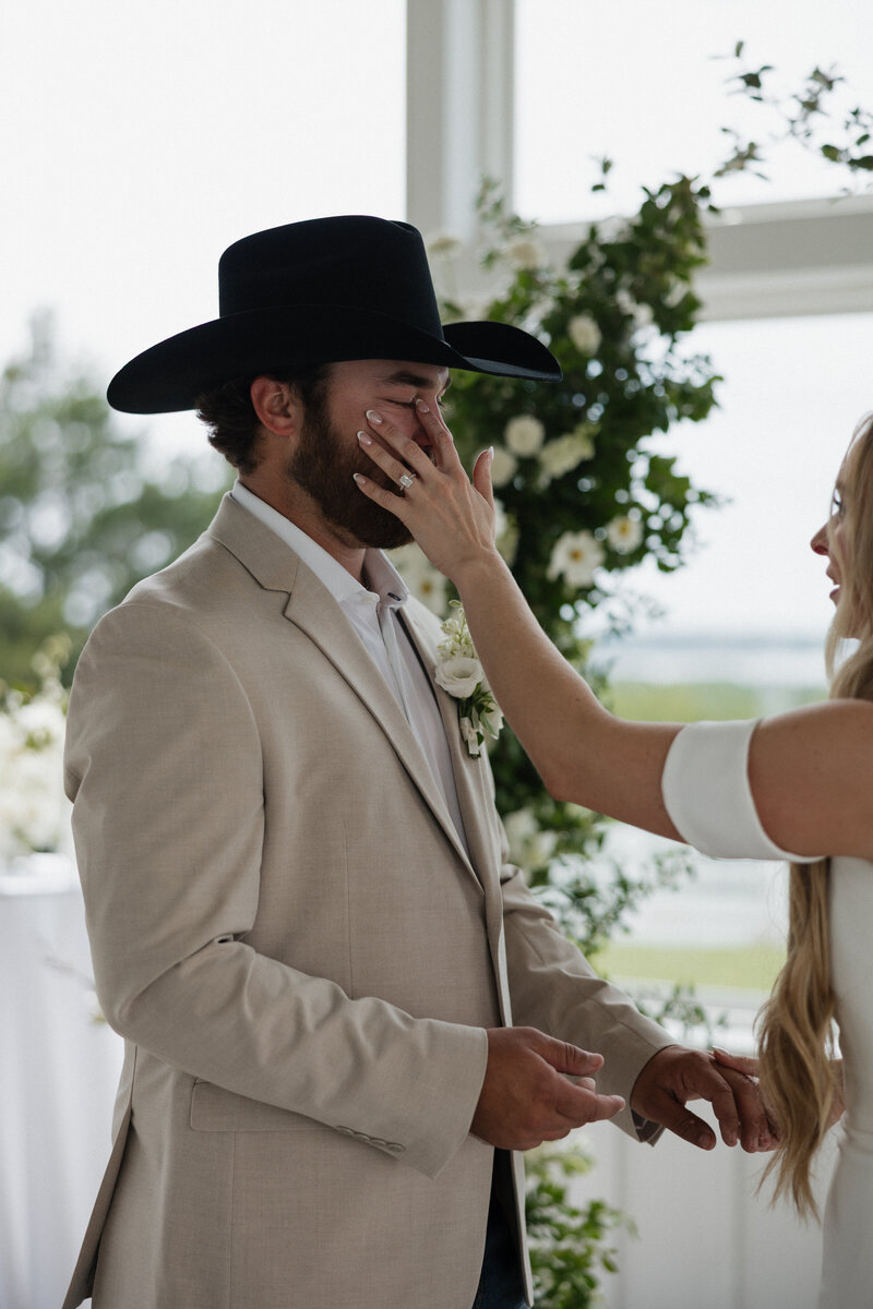 Bride wiping her groom's tears after sharing private vows