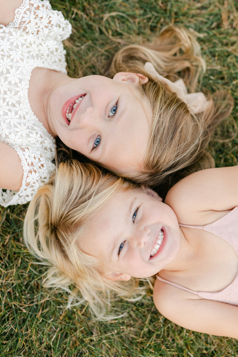 two little girls lying in the grass