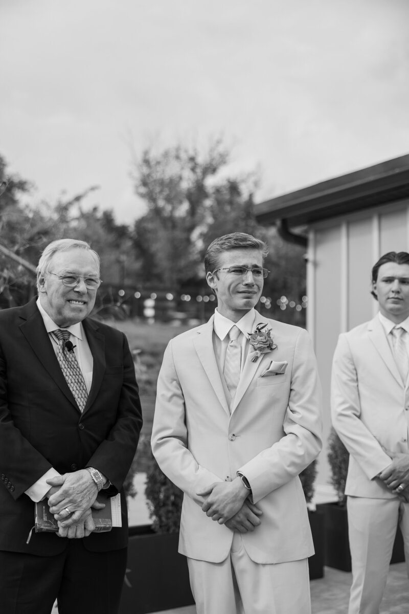 Groom standing at the end of the aisle crying as the bride walks down at Hazelnut Farm