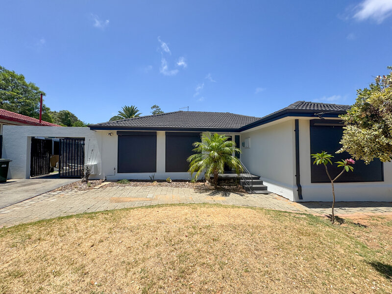 Exterior of house in Mandurah with dark grey roof, shutter and steps. The render walls are light grey.