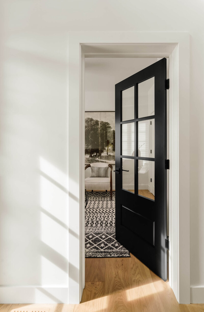 Home office with farmhouse style door and geometric black and white artwork. 