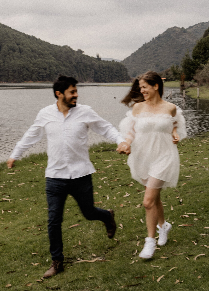 couple playfully running in a park for their New Jersey portrait photography