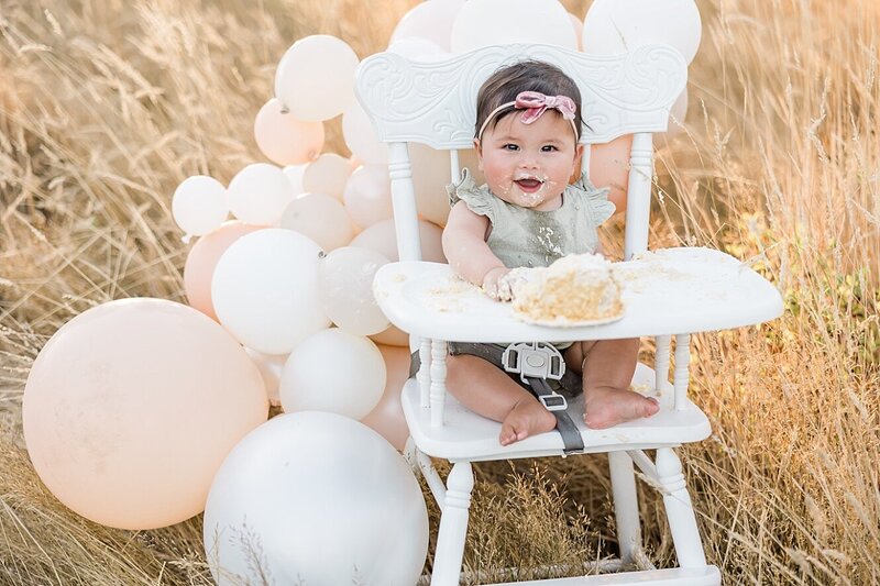 Baby boy with hat and cake in outdoor photography session for first birthday by Ann Marshall