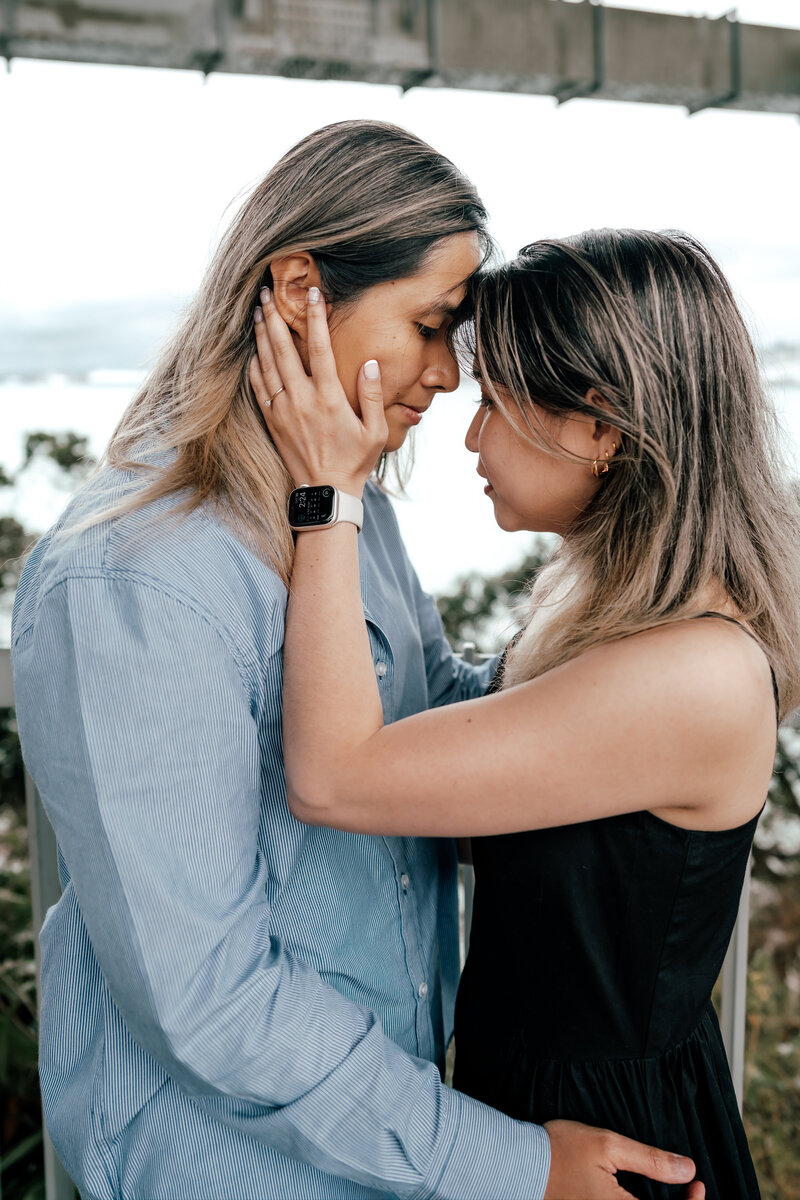 A LGBTQ couple resting their foreheads together as the one woman holds the other womans face and both closing their eyes - Zanthe Vorsatz Photography