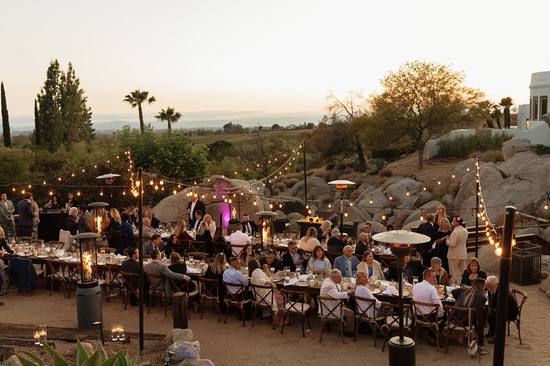 Guests enjoying dinner at a elaborate backyard wedding at a San Diego estate