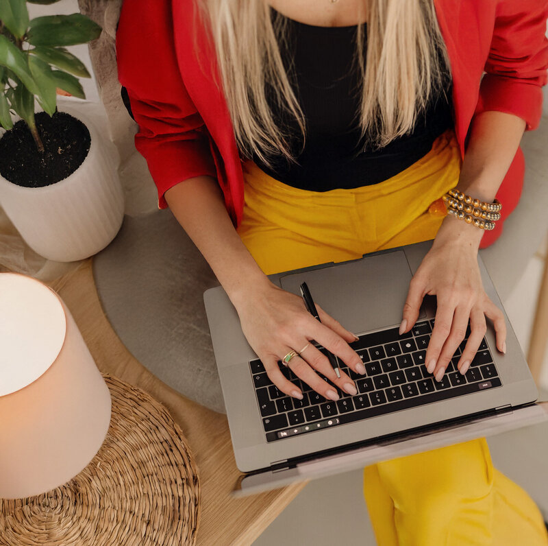 Woman working on a laptop in a modern, sunlit space, representing career and internship opportunities in somatic psychotherapy in NYC.
