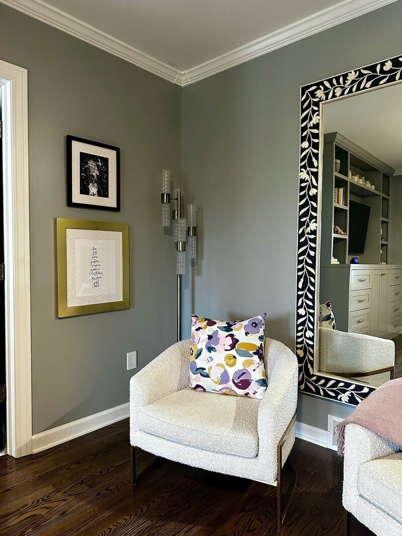 Modern sitting area with a white chair and a colorful throw pillow with a playful pattern