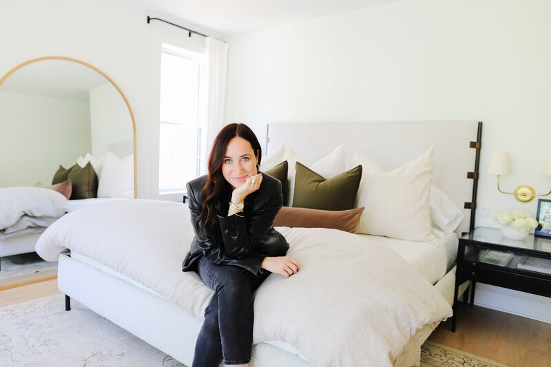 woman sits on bed