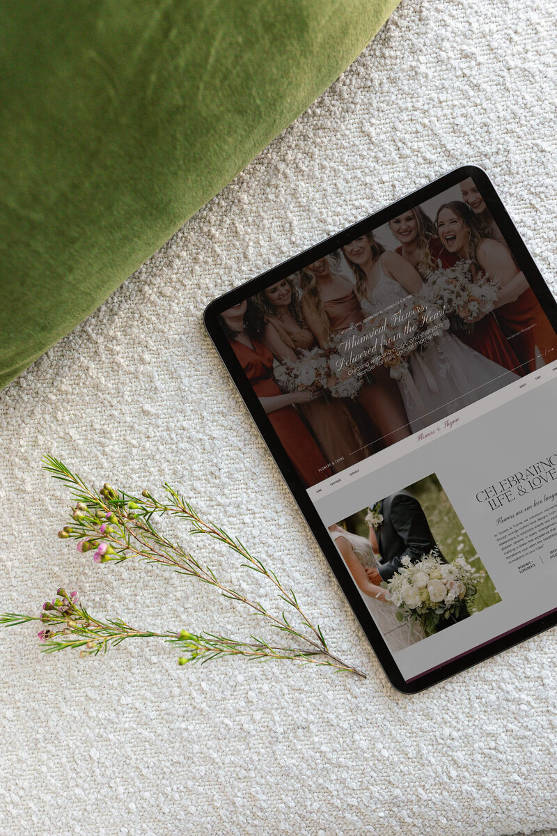 An ipad next to flowers demonstrating a florist's homepage designed by Eugene website designer Bloem Creations. 