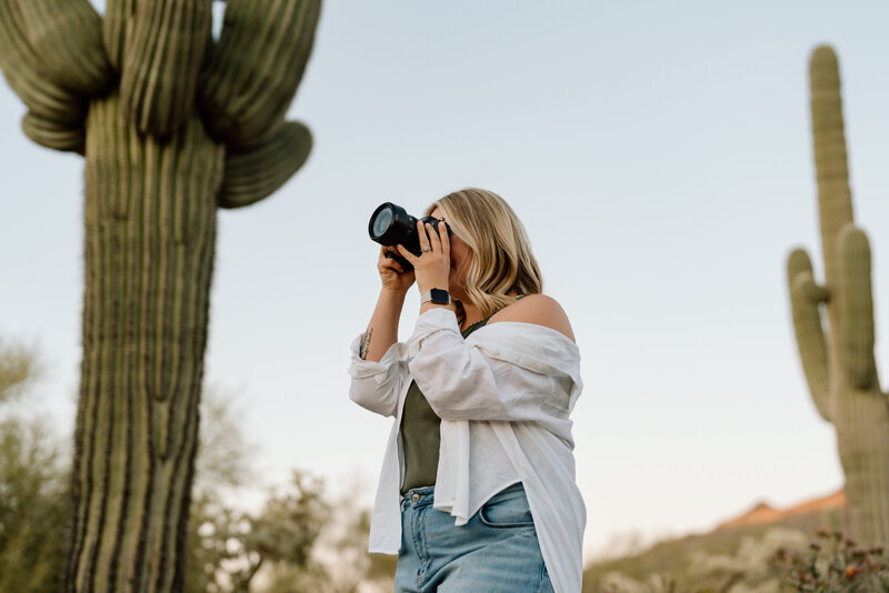 woman taking photo under cactus