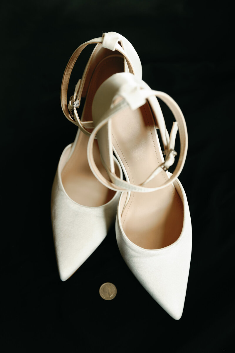 Wedding at Dover Hall in Manakin-Sabot, VA | Luxury Wedding Photographer in Virginia | detail photo of white wedding heels and a sixpence for tradition at luxury wedding venue, Dover Hall