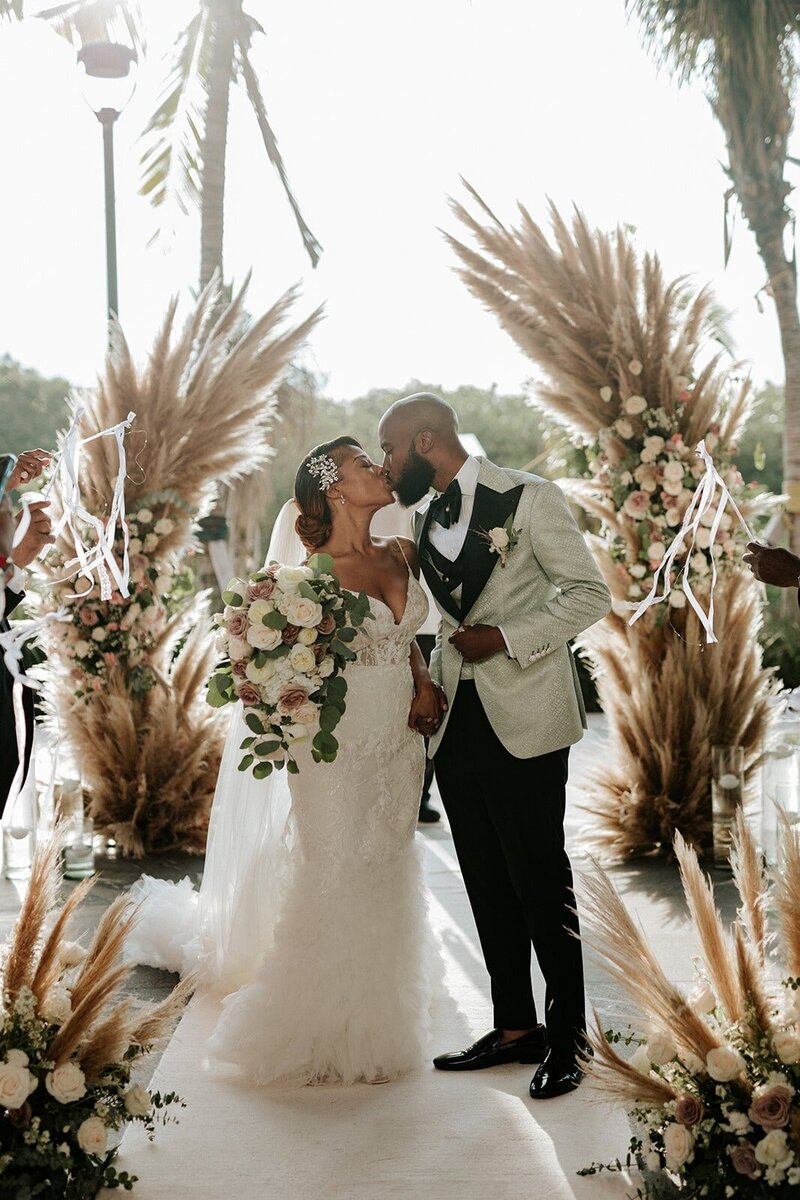 A bride and groom get married on a lavish beach.