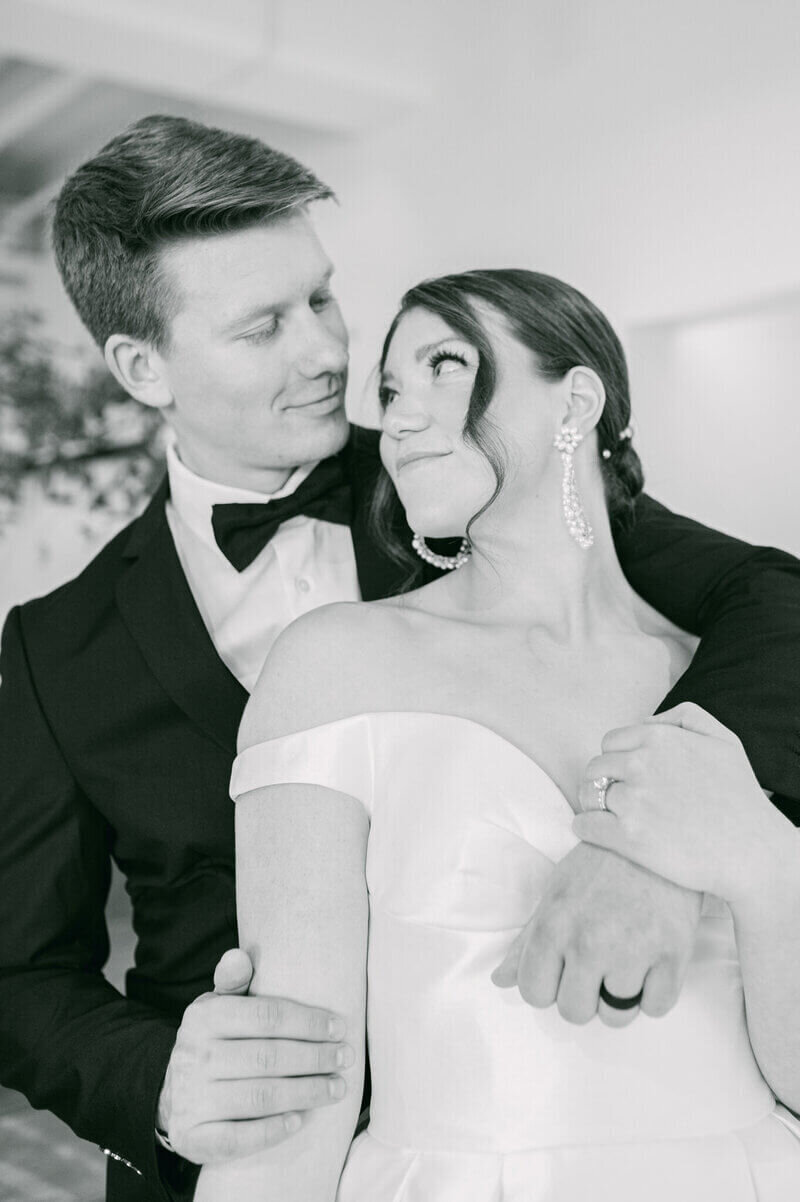 Black and white photo of bride and groom smiling at one another at wedding by chicago event planners.