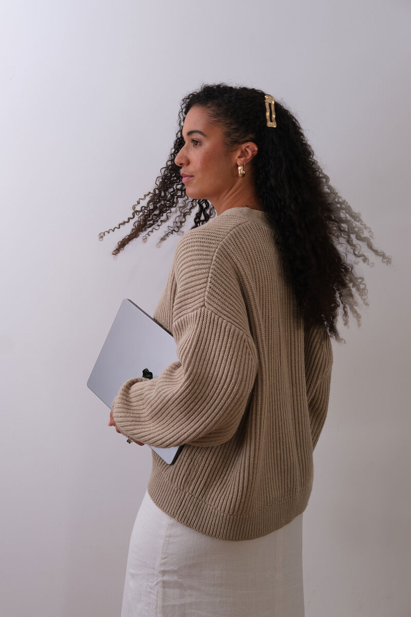 Woman flipping her hair holding laptop